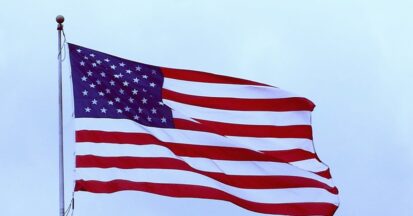 The flag of the United States against a blue sky