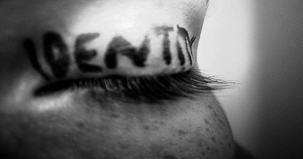 The word identity written on a woman's eyelid