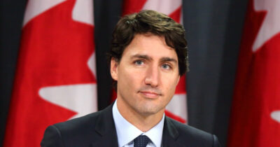 Justin Trudeau in front of the flag of Canada