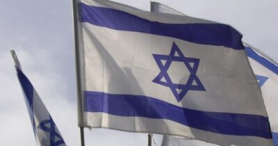 The flag of Israel against a blue sky
